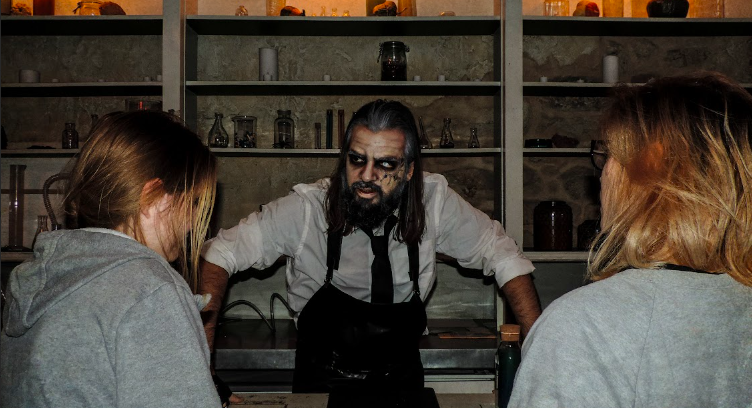 Comédien en costume de savant fou dans un laboratoire d'escape game