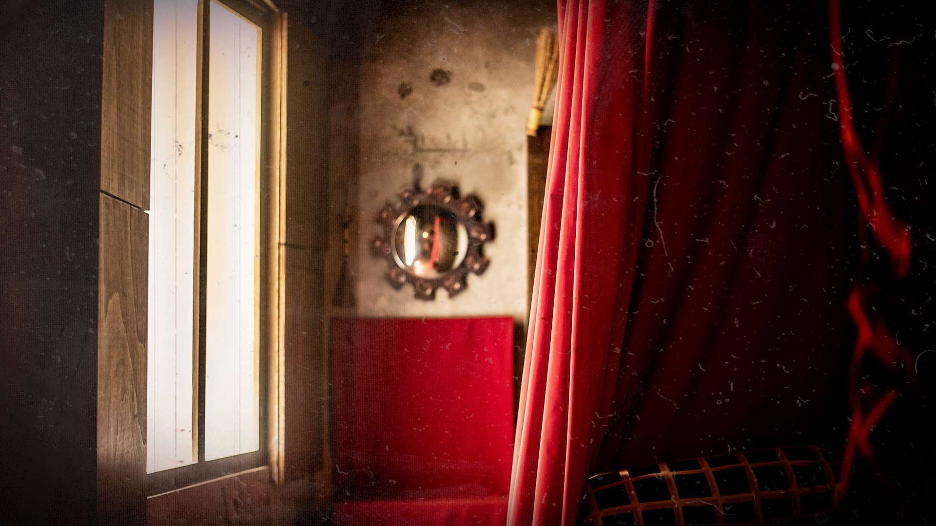 Ambiance mystérieuse avec rideaux rouges et miroir dans escape game