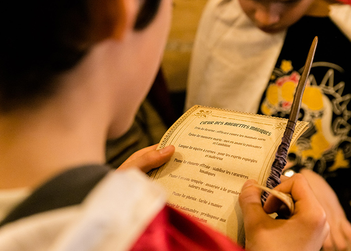 Joueurs lisant un grimoire de magie dans un escape game